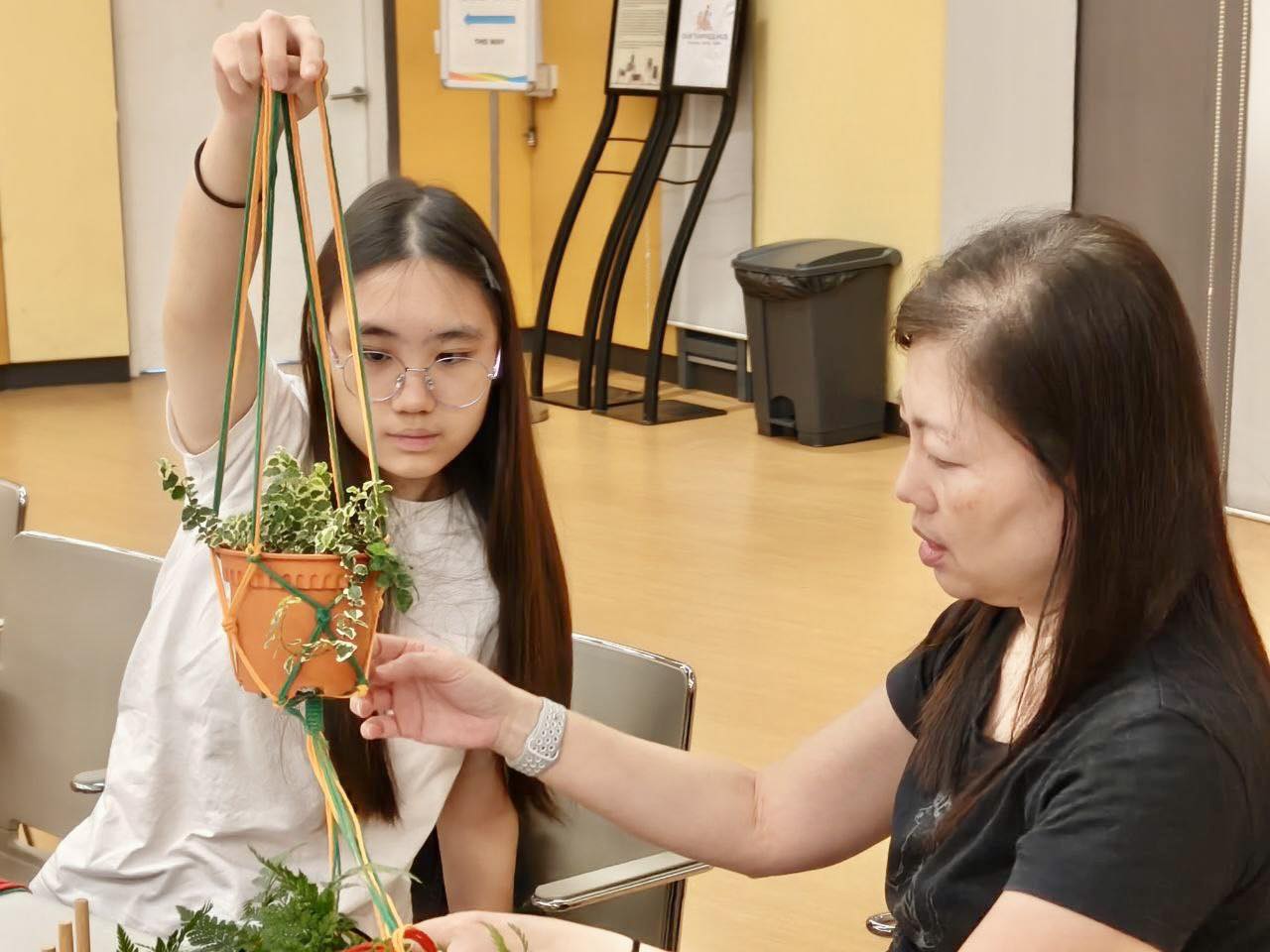 Participants learning macrame knotting techniques
