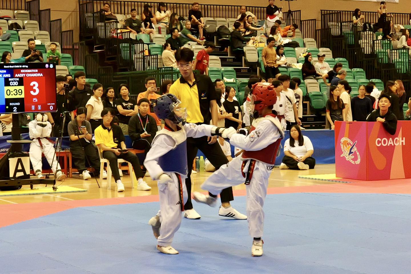 Spectators cheering on athletes at the Singapore Open Taekwondo event