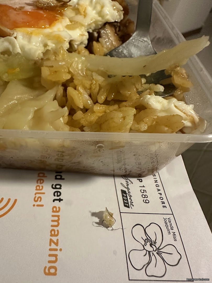 A container of rice and egg sits on a Singapore Post envelope.