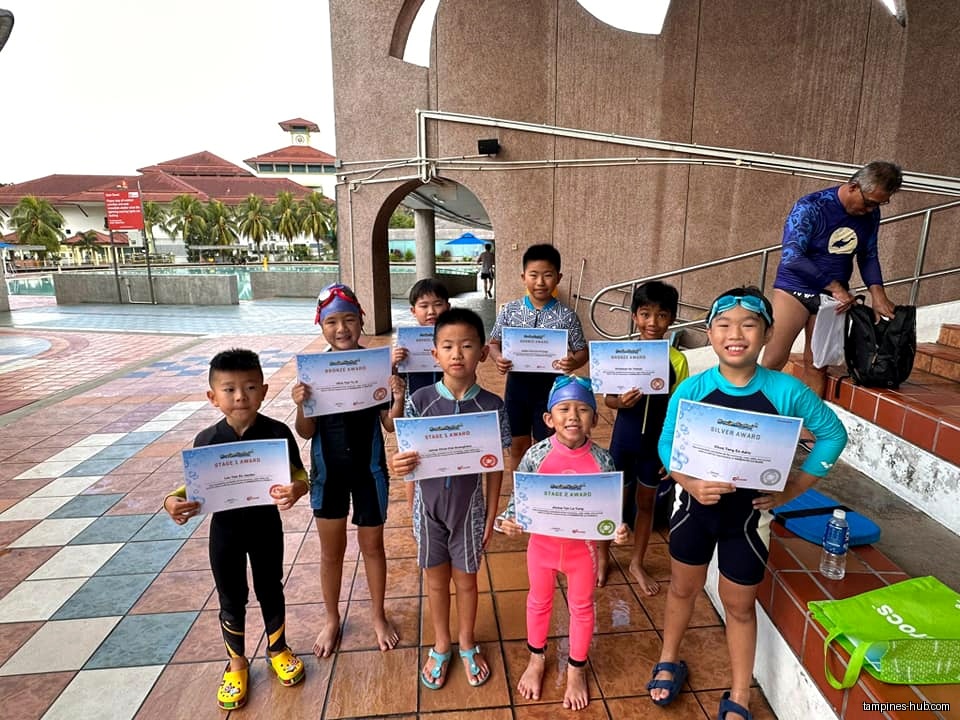 Children in swimwear hold awards at Ace Dolphin Swim School in Tampines.