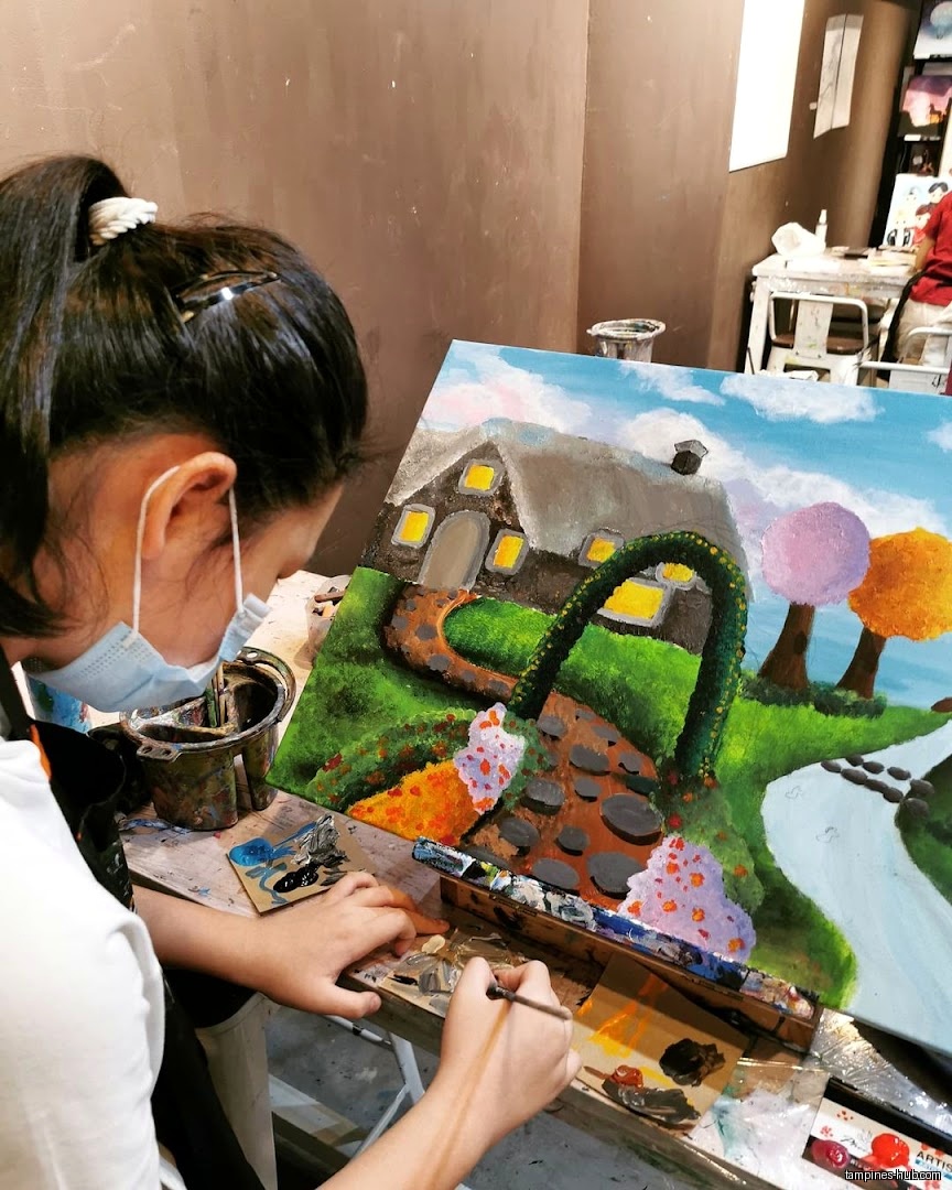 A person is painting a landscape with a house on canvas.