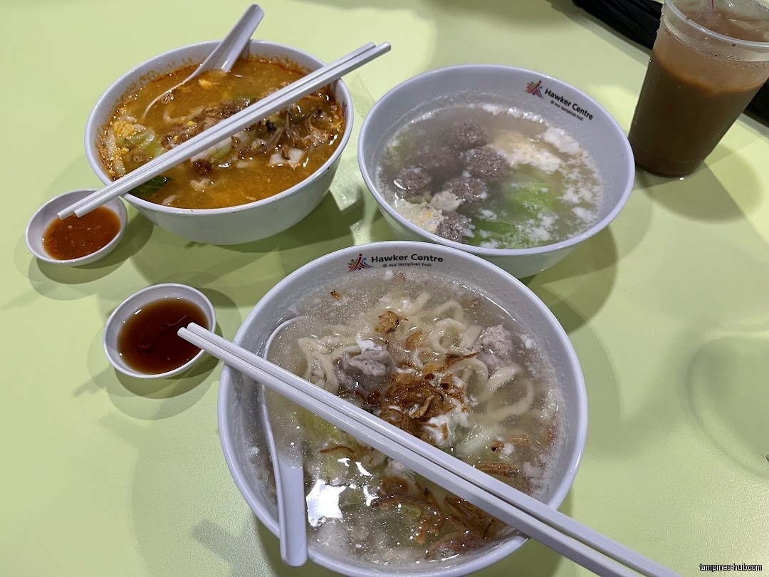 Three bowls of Ban Mian soup with toppings and dipping sauces are on a table.