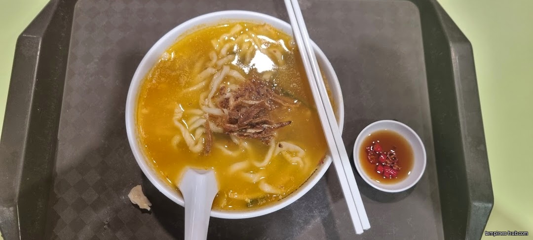 A bowl of Ban Mian soup with chopsticks and chili sauce on a tray.