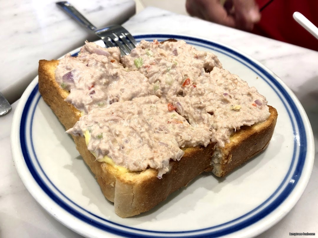 Tuna salad toast on a blue-rimmed plate with a fork.