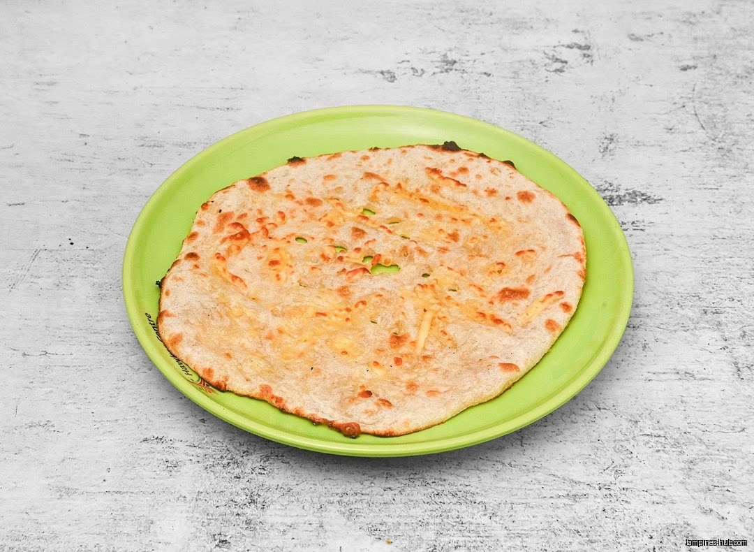 A flatbread with cheese on a green plate, likely from Best Zaika.