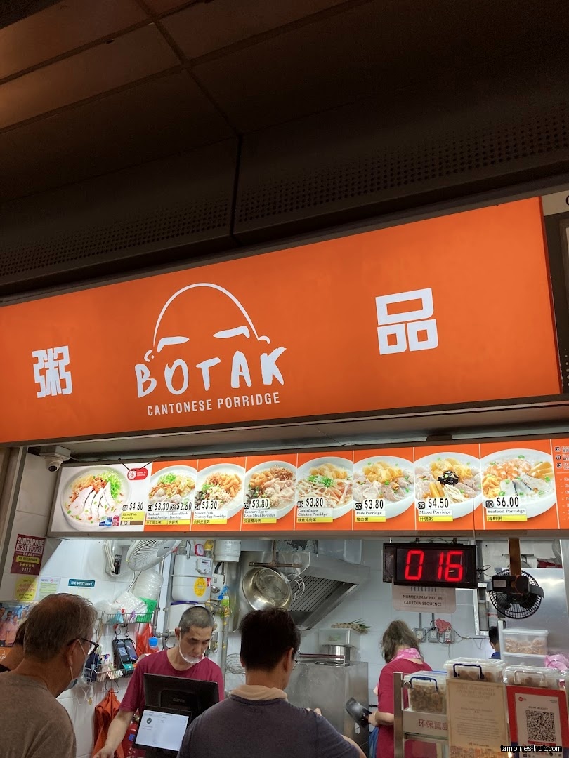 Botak Cantonese Porridge shop front with menu board and customers.