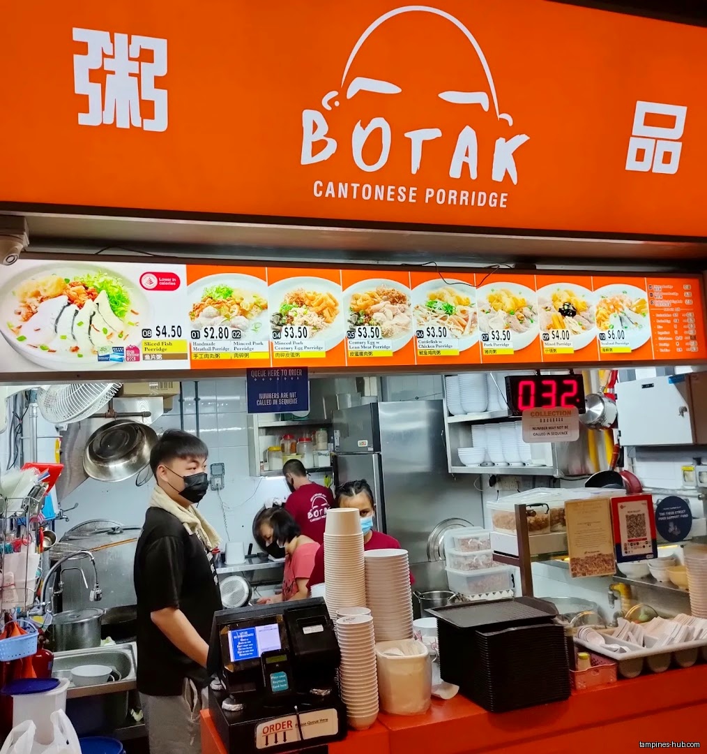 Botak Cantonese Porridge shop interior with staff and menu board visible.