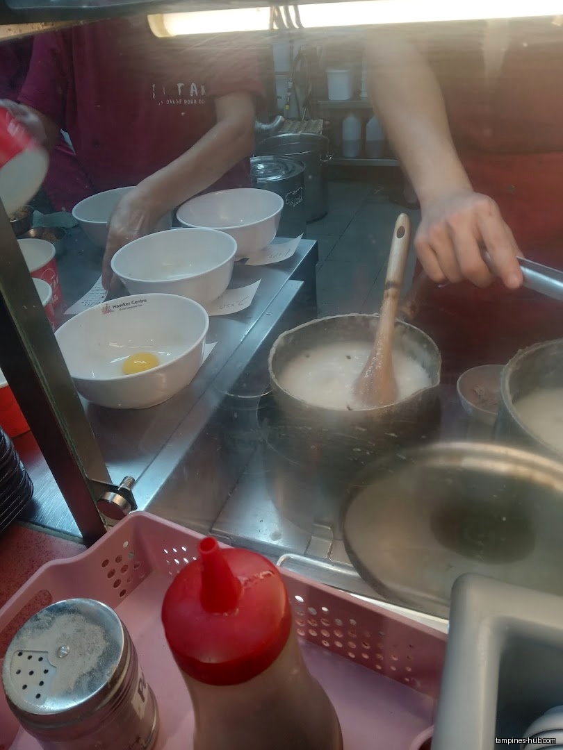 Cantonese porridge being prepared with bowls, pots, and condiments visible.