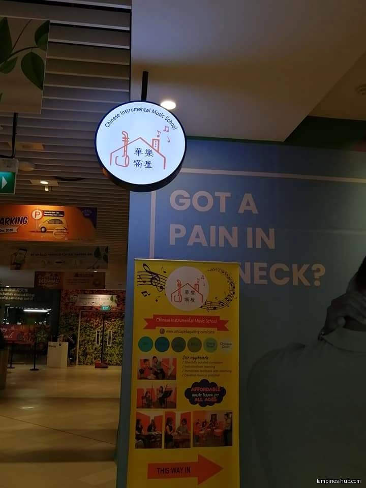Image shows a sign and promotional banner for a music school.