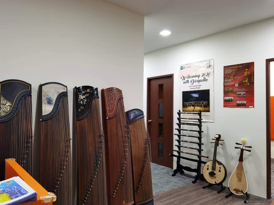 The image shows various Chinese musical instruments inside the music school.