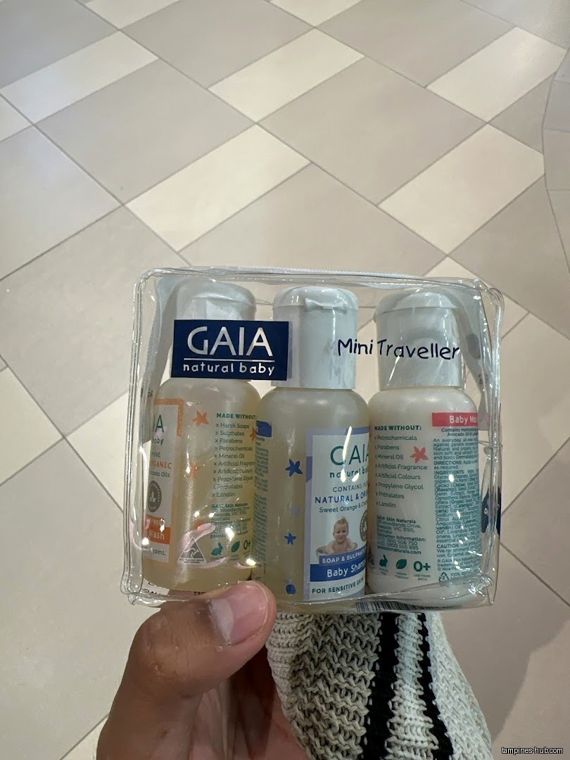 A hand holds a travel pack of Gaia natural baby products.