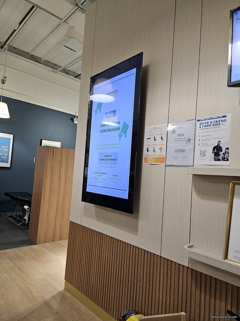 Interior view of Chiropractic Singapore @ Tampines with operating hours display.