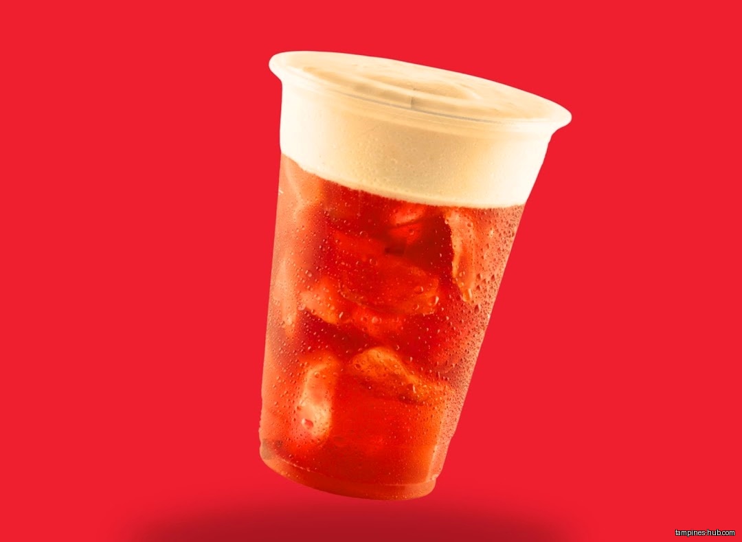 A plastic cup filled with red liquid and a creamy topping.