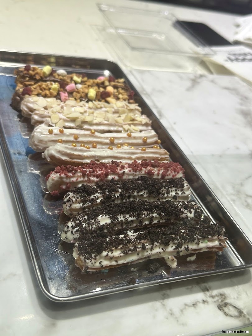 A tray of assorted churros with different toppings is displayed.
