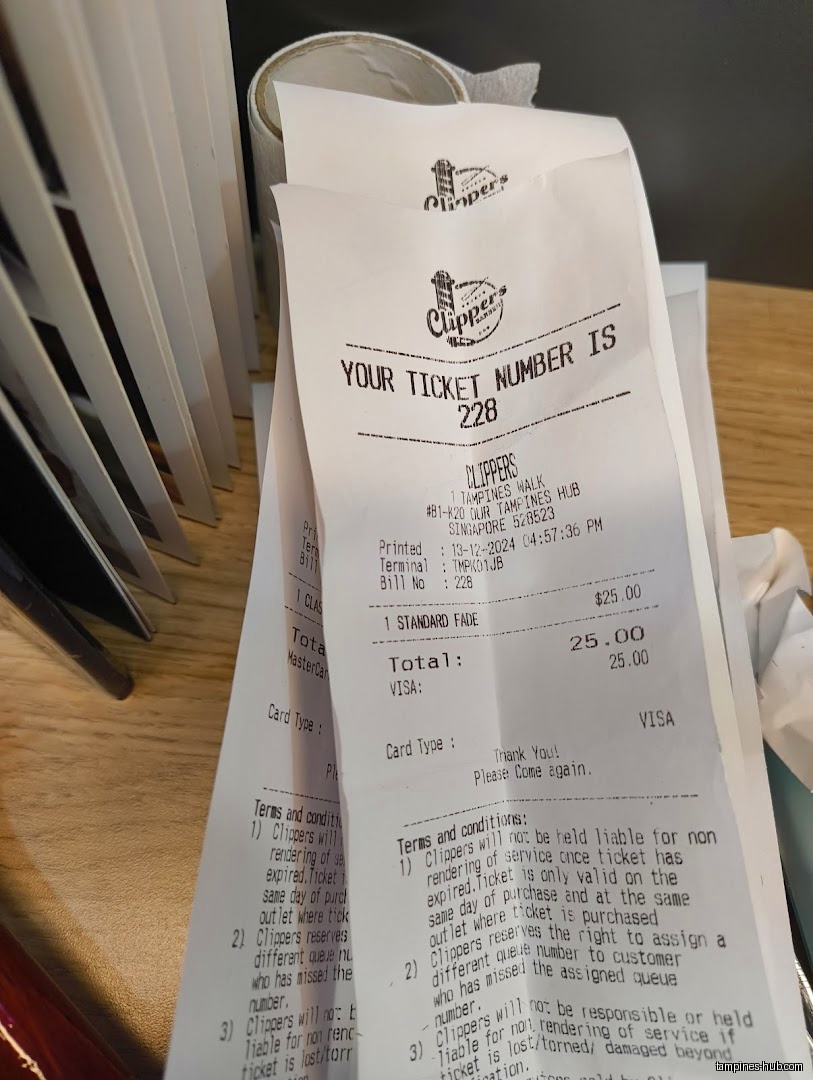 Close-up of Clippers Barber receipts showing ticket number, service, and terms.