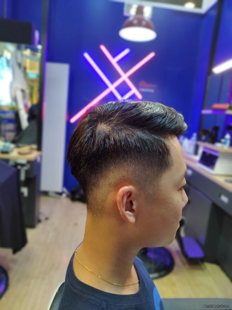 A man with a fresh haircut inside Clippers Barber Our Tampines Hub.