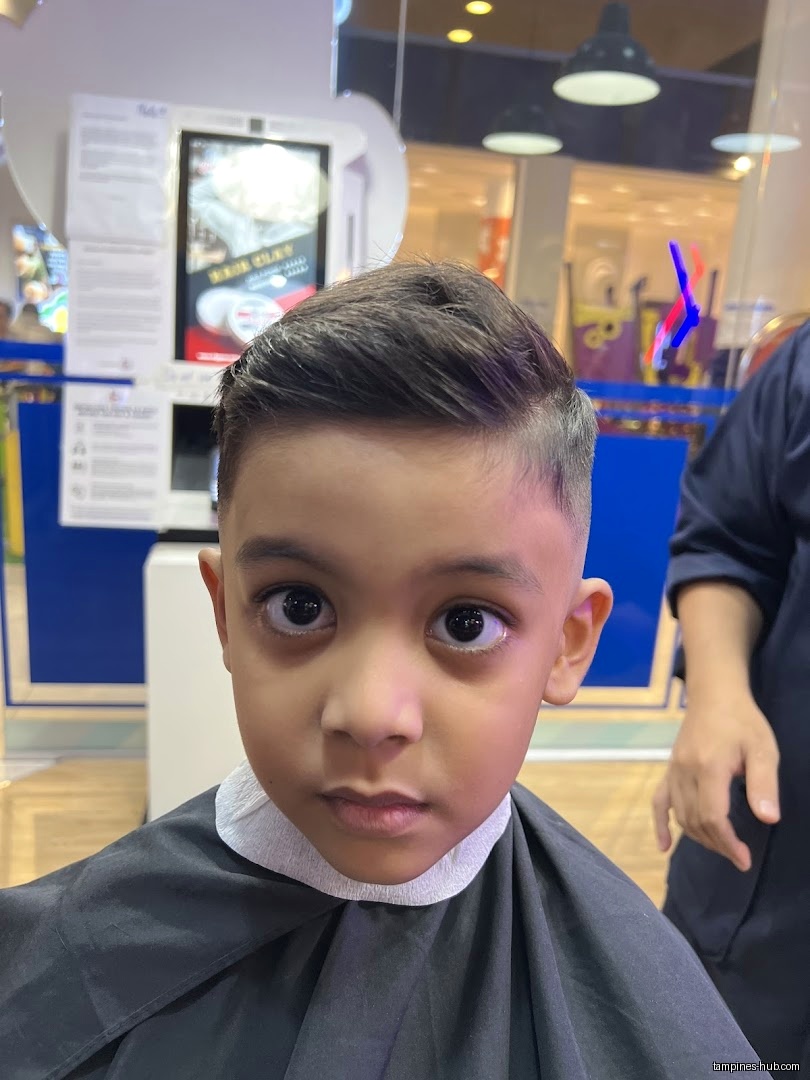 A young boy with a fresh haircut at Clippers Barber shop.