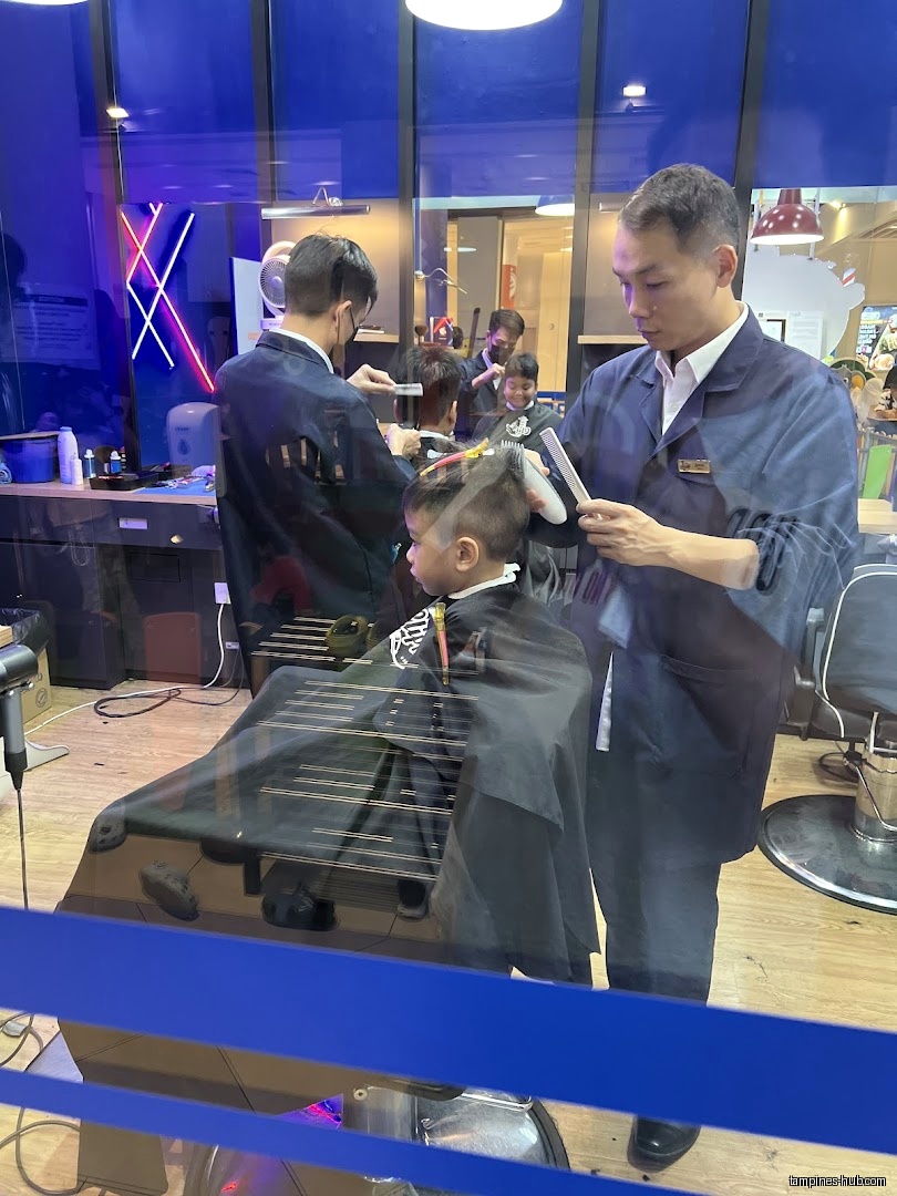 Inside Clippers Barber, barbers are cutting children's hair in barber chairs.