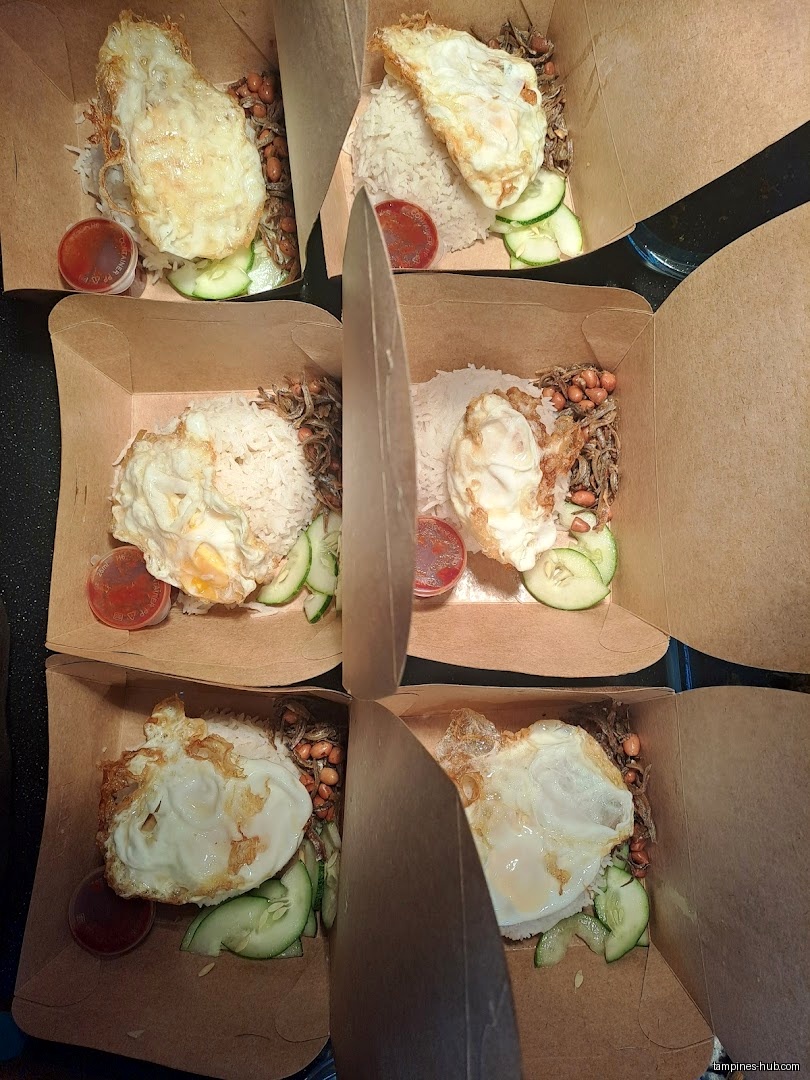 Several boxes of Nasi Lemak with fried egg, rice, and condiments.