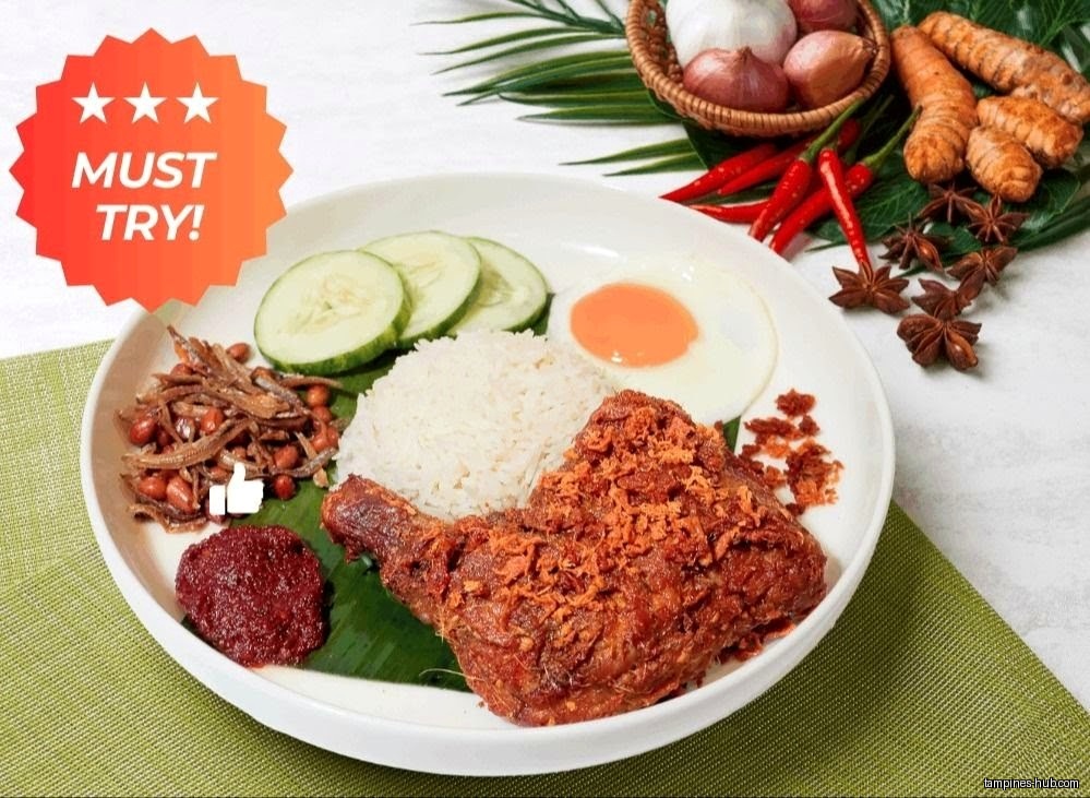A plate of Nasi Lemak with fried chicken, rice, and other ingredients.