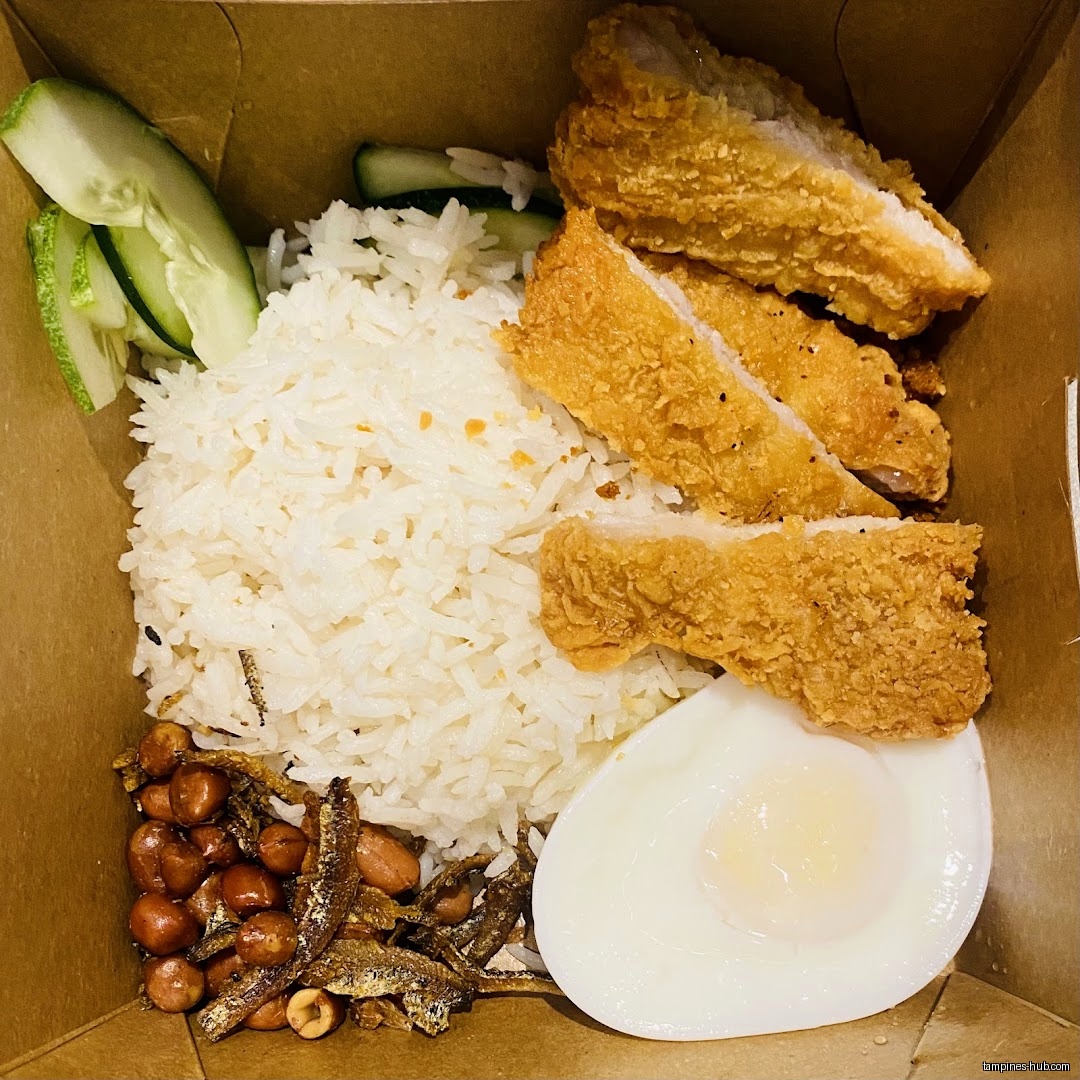 A box of Nasi Lemak with fried chicken, egg, and other toppings.
