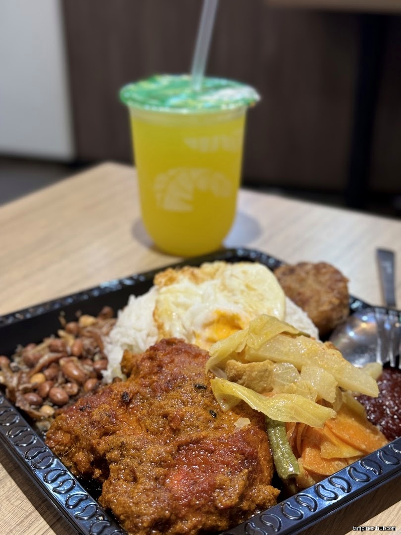 A tray of Nasi Lemak with a drink on a table.