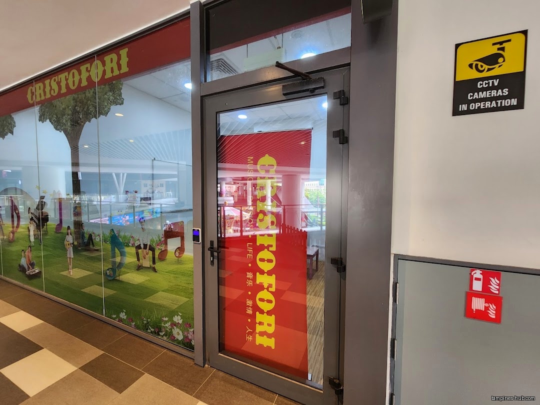 Cristofori Music School entrance with glass window and security camera sign.