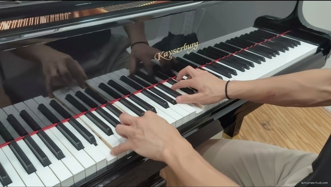 A person is playing a Kayserburg grand piano.