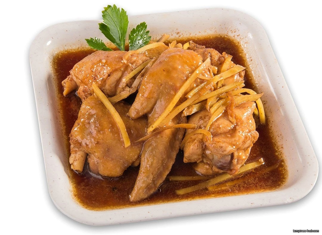 A plate of braised chicken with ginger in a brown sauce.