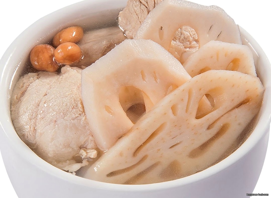 A bowl of herbal soup with lotus root, meat, and peanuts.