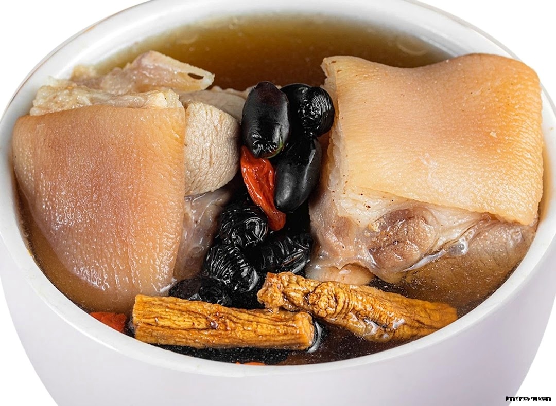 A bowl of herbal soup with meat, dates, and other ingredients.