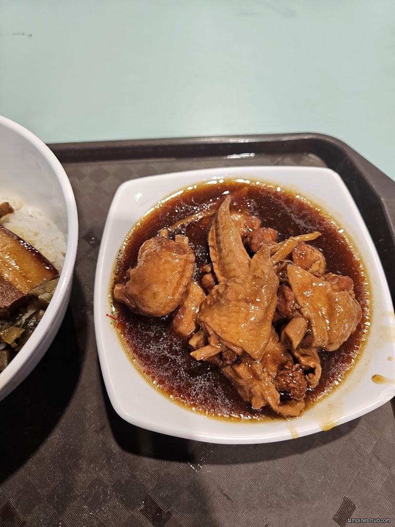 A plate of braised chicken and a bowl of rice on a tray.