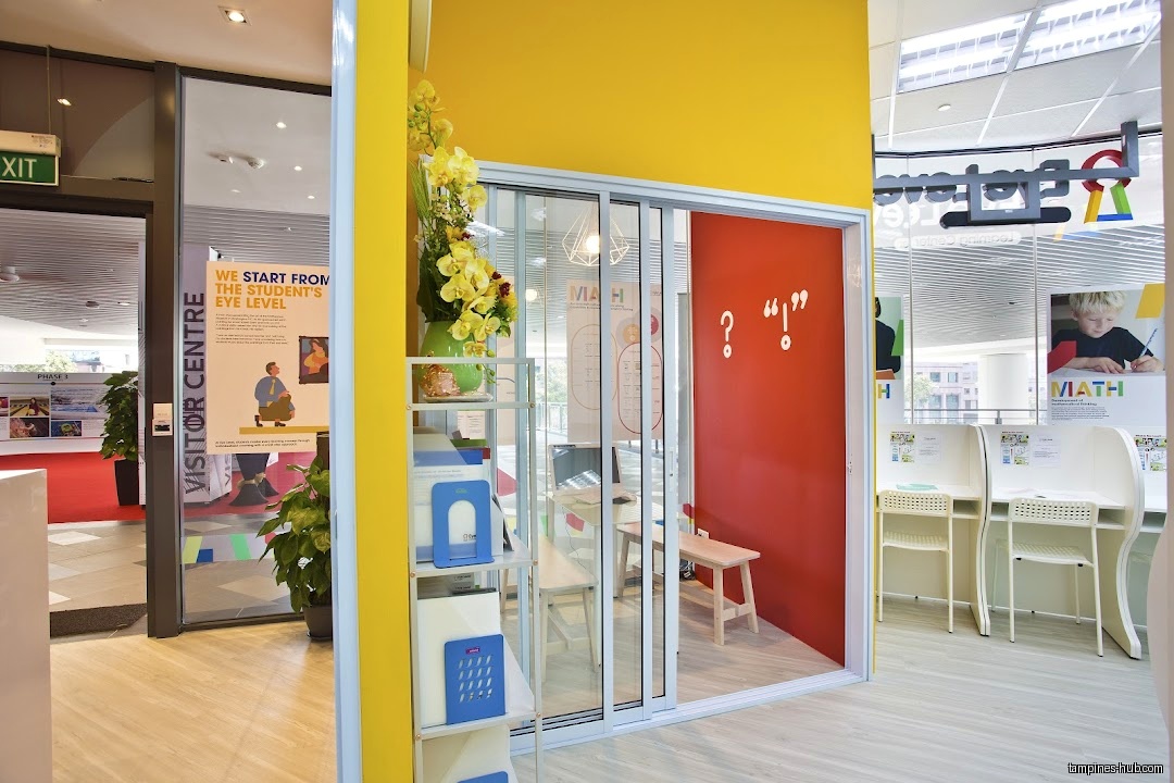 Eye Level Learning Centre entrance with desks, posters, and a small room.