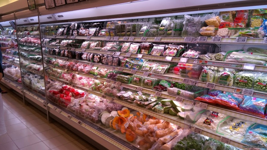 A refrigerated display case filled with packaged vegetables and produce at FairPrice.