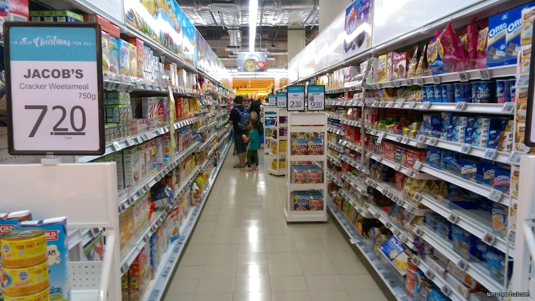 Aisles in FairPrice Our Tampines Hub supermarket with shelves stocked with groceries.