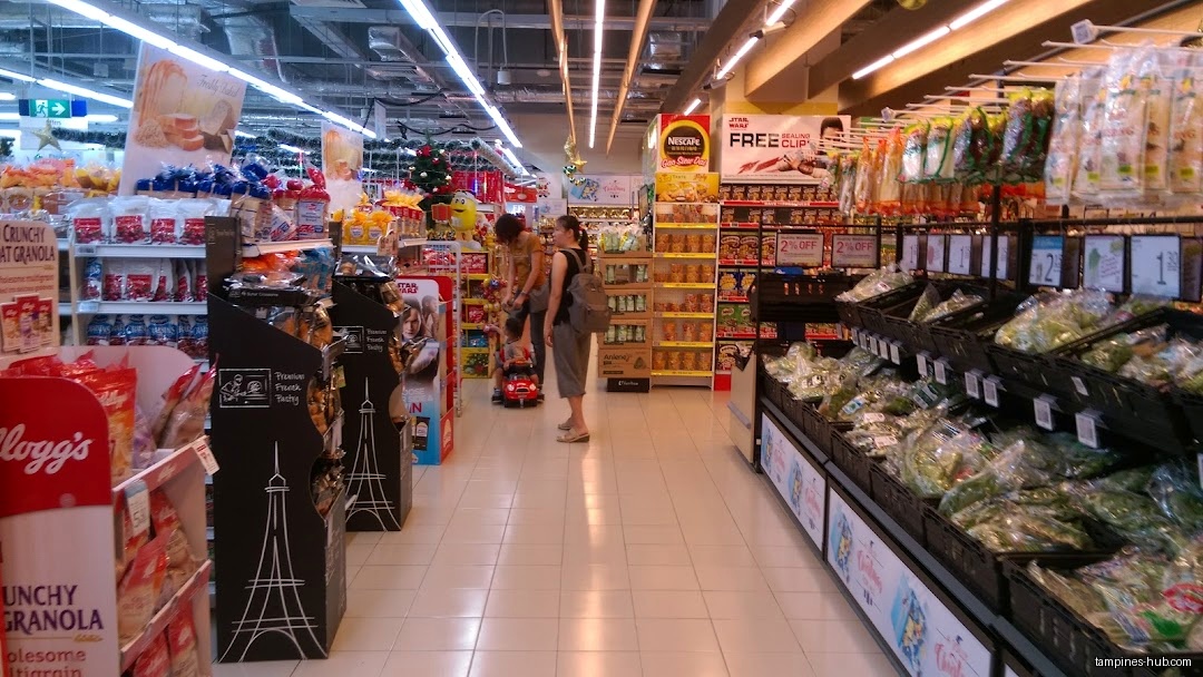 Aisles of FairPrice Our Tampines Hub with groceries and shoppers.