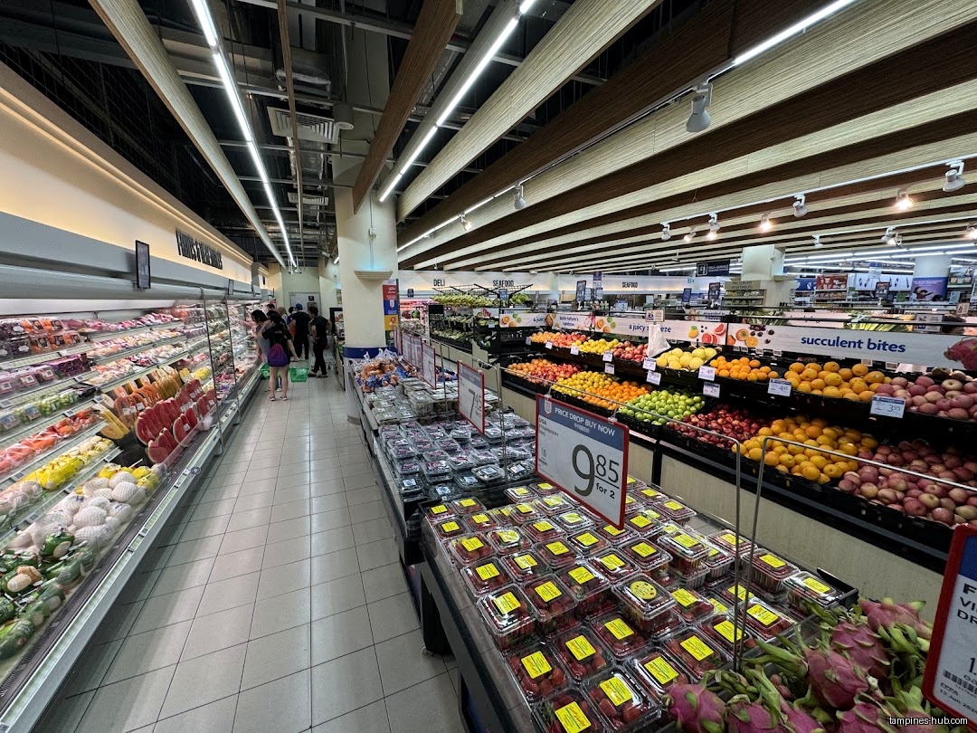 Interior view of FairPrice Our Tampines Hub, showing produce and shoppers.