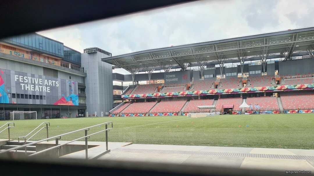 Festive Arts Theatre exterior view with stadium seating and a soccer field.