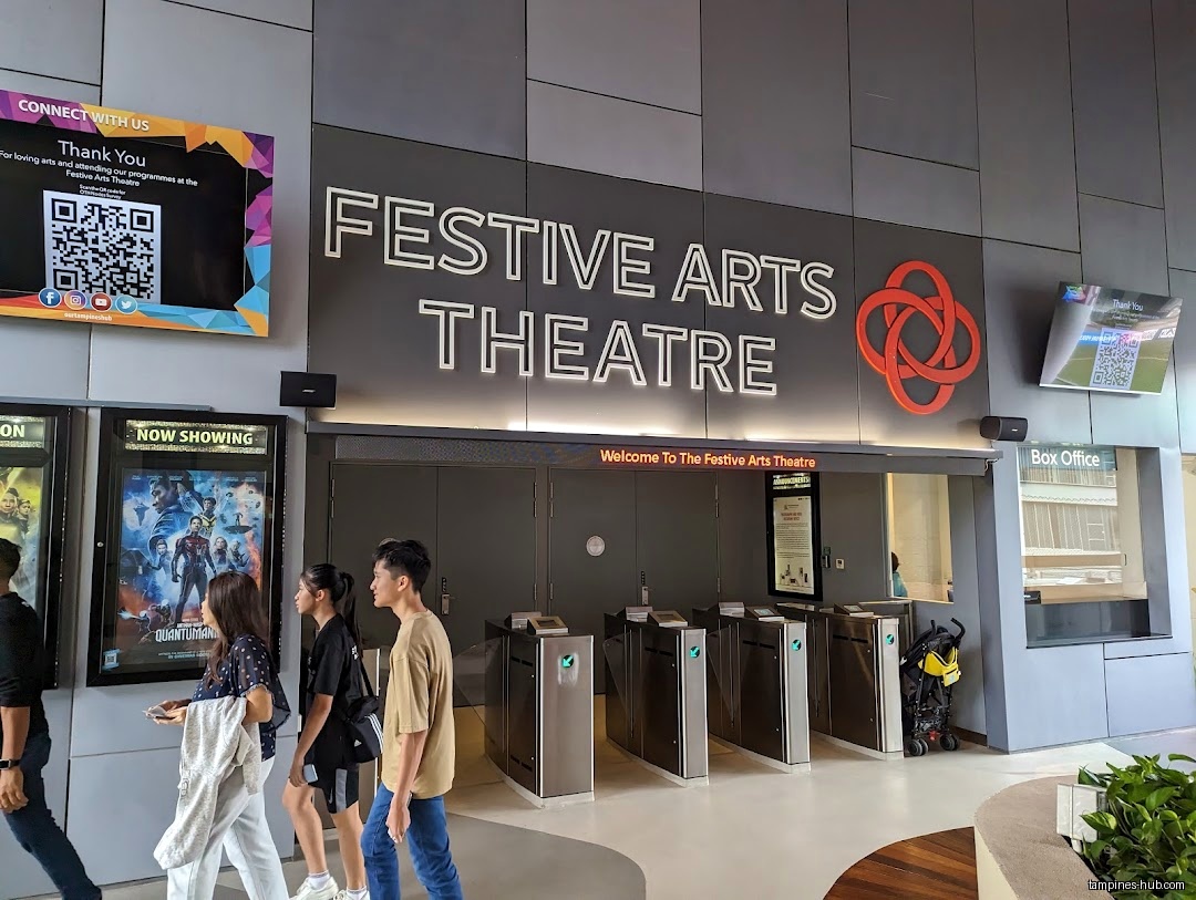 Festive Arts Theatre entrance with people, posters, and a box office.