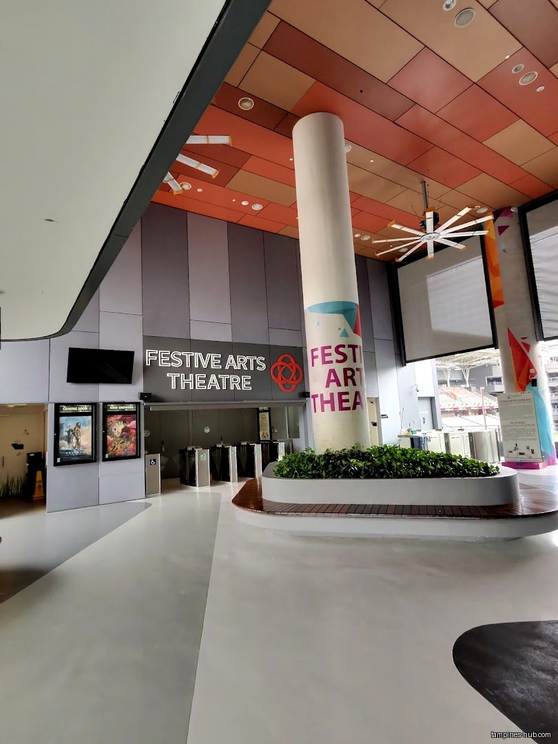 Festive Arts Theatre entrance with posters, turnstiles, and a central pillar.