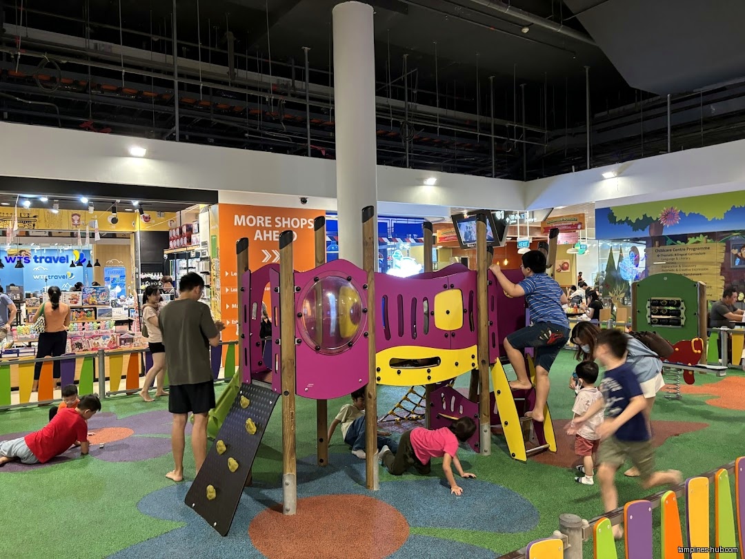 Children play on colorful playground equipment inside Festive Mall Play Zone.