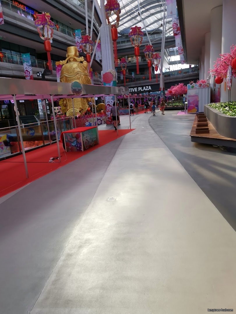 Festive Plaza interior with decorations, stalls, and people walking through the space.