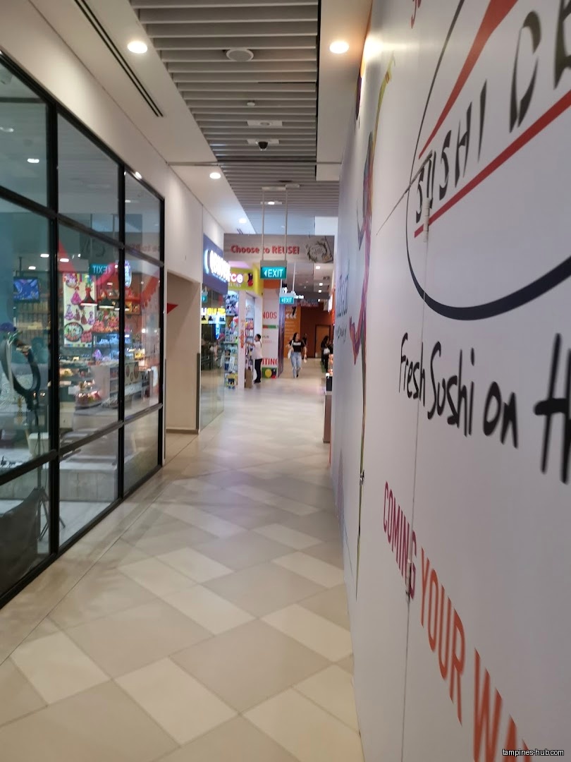 A hallway in Festive Plaza with shops and a sushi restaurant advertisement.