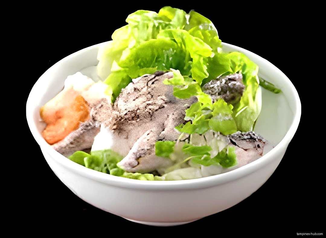 A white bowl contains fish, lettuce, and other ingredients.