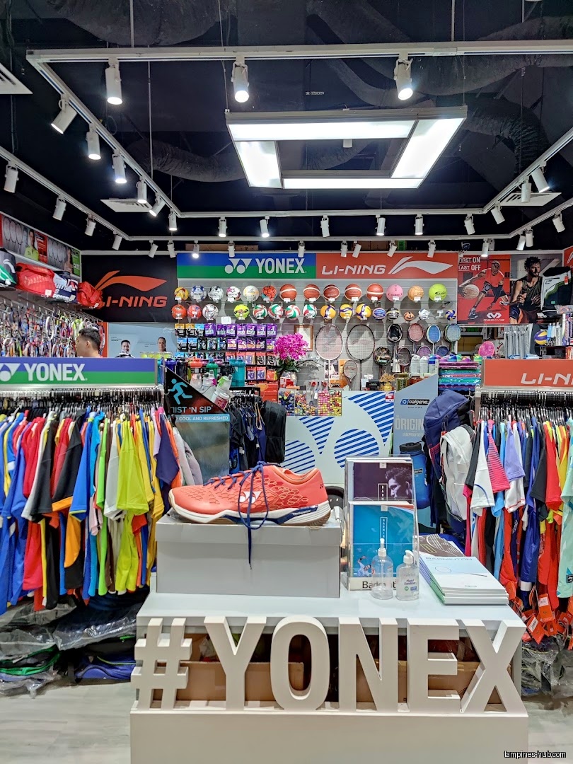 Flymax shop interior with Yonex display, clothing racks, and sports equipment.