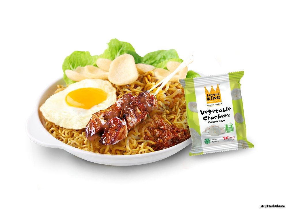 A plate of noodles with egg, satay, and a pack of crackers.