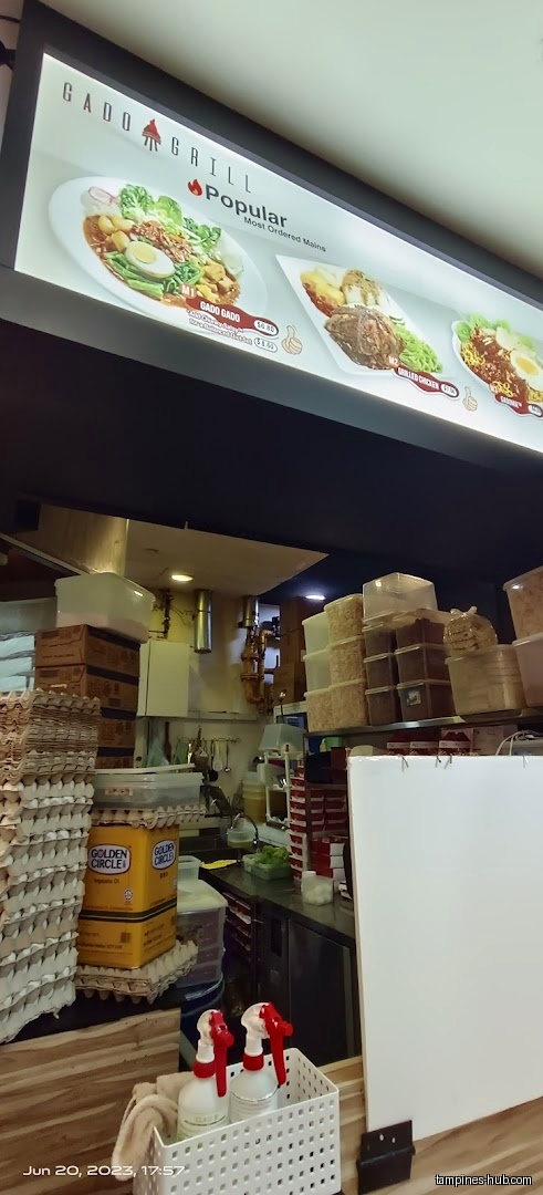 The image shows the interior of Gado & Grill with a menu board.