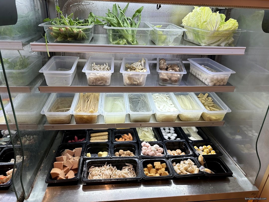 A refrigerated display case shows various food items in plastic containers.