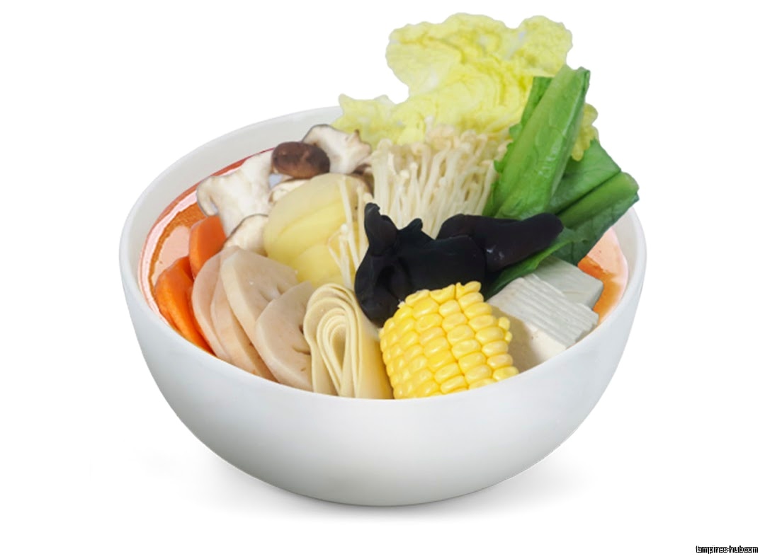 A bowl of Ma La Tang with vegetables, mushrooms, tofu, and corn.