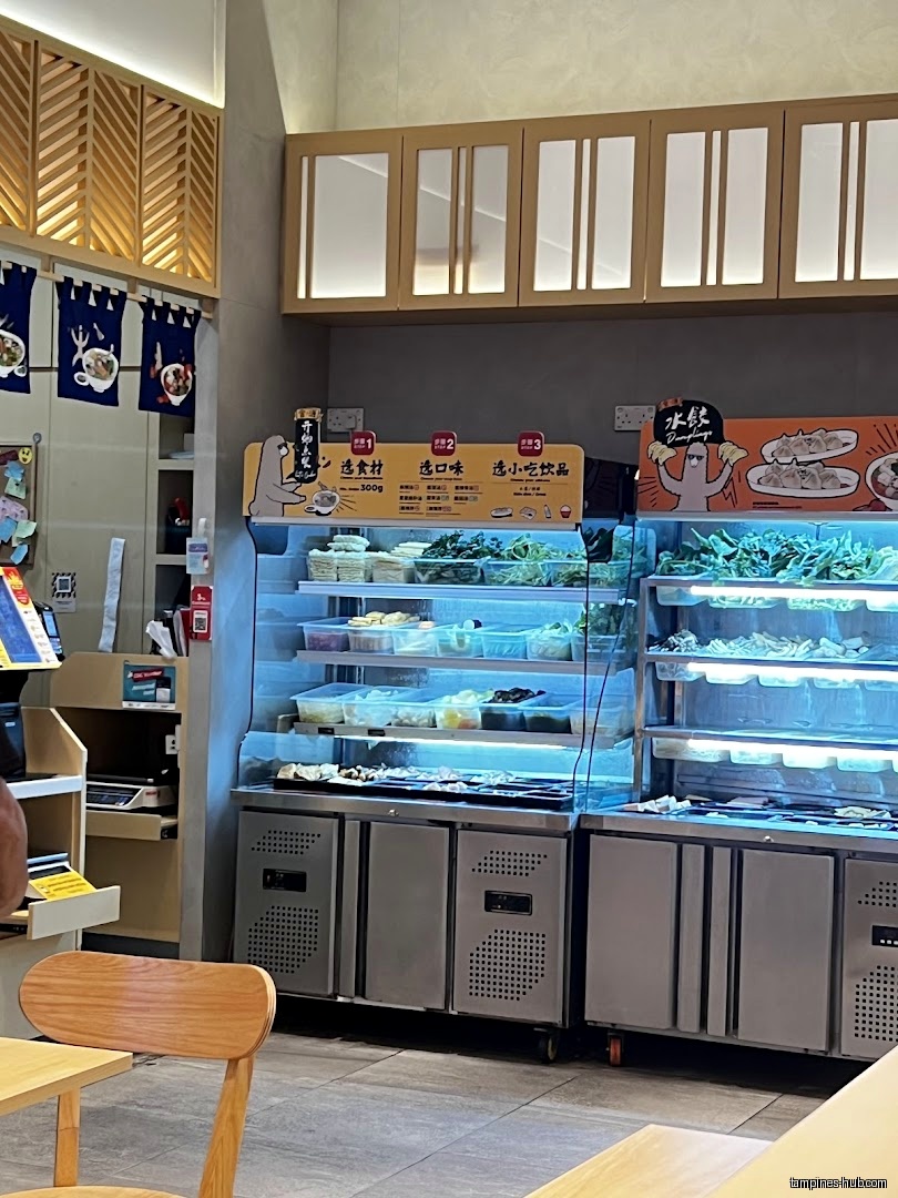 The image shows a refrigerated display case with food items inside a restaurant.